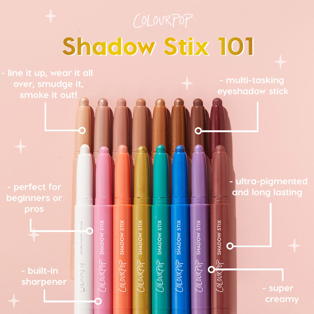 ColourPop Shadow Stix lineup featuring Cold Girl, creamy multi-tasking eyeshadow stick, stands uncapped in rainbow shades on a blush-pink backdrop, highlighting built-in sharpener, ultra-pigmented long-wear formula for lining, smudging, and all-over wear.